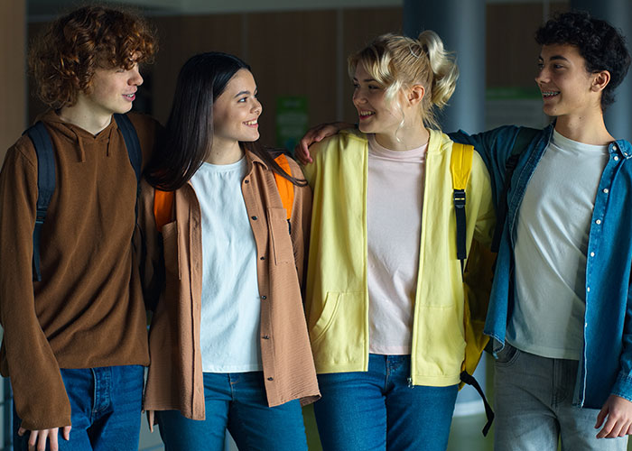 Group of young people sharing and smiling, illustrating the concept of people learning things embarrassingly late in life.