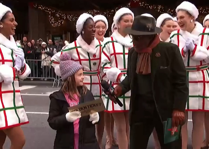 Little girl holding golden ticket with dancers around her during Thanksgiving parade, showing a candid reaction. Little girl holding golden ticket with dancers around her during Thanksgiving parade, showing a candid reaction.