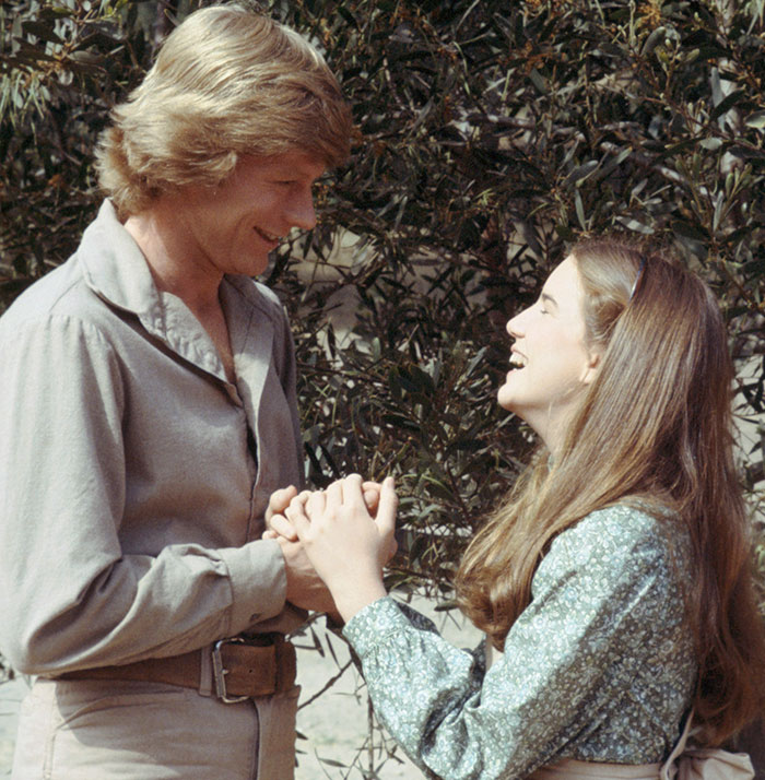 Melissa Gilbert and her on-screen husband holding hands outdoors, highlighting the age gap in their roles.