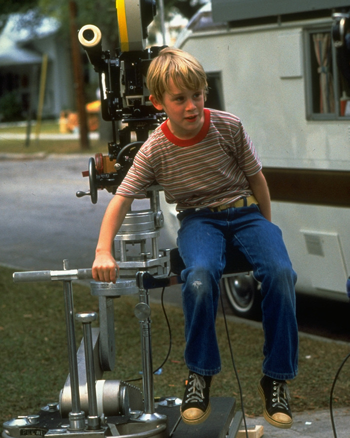 Young Macaulay Culkin on set of My Girl, sitting on film equipment during the filming of a tragic scene. Young Macaulay Culkin on set of My Girl, sitting on film equipment during the filming of a tragic scene.