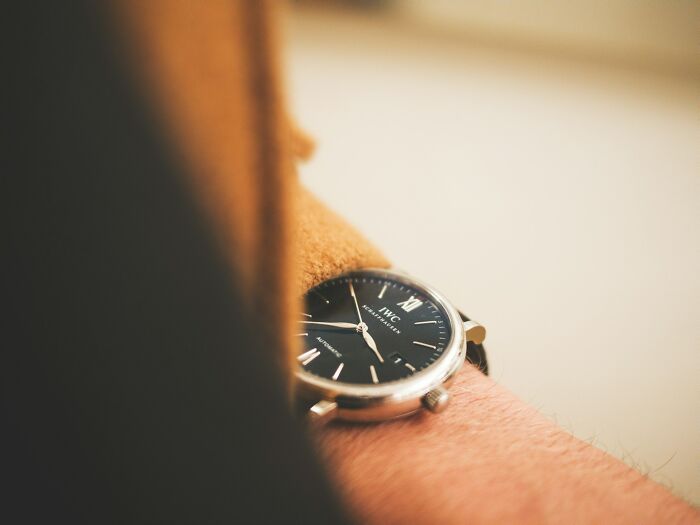 Close-up of a wristwatch on a person's arm, illustrating subtle signs that indicate they’re cheating in a relationship.