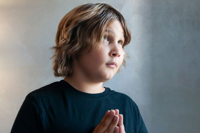 Young person in black shirt looking up thoughtfully, reflecting on cancer and insensitive comments during hard times.