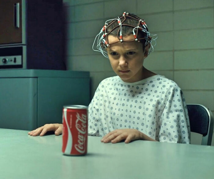 Millie Bobby Brown in hospital gown with electrodes on head, representing bullying faced by Stranger Things star.