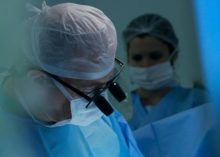 Surgeons in scrubs and masks performing surgery, highlighting medical malpractice lawyer insights on everyday dangers.