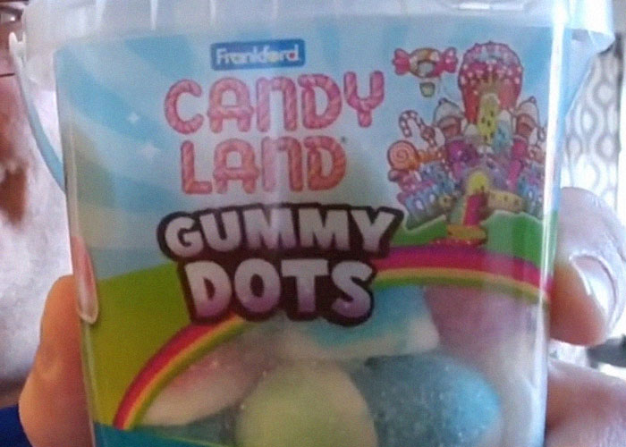 Container of Candy Land Gummy Dots held by hand, illustrating dangerous things in everyday life related to medical malpractice.