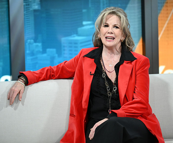 Melissa Gilbert seated on a couch during an interview, wearing a red jacket and black outfit, discussing age gap feelings.