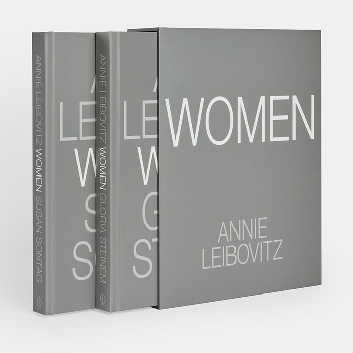A set of Annie Leibovitz photography books titled Women with grey covers, stacked neatly on a white surface. A set of Annie Leibovitz photography books titled Women with grey covers, stacked neatly on a white surface.