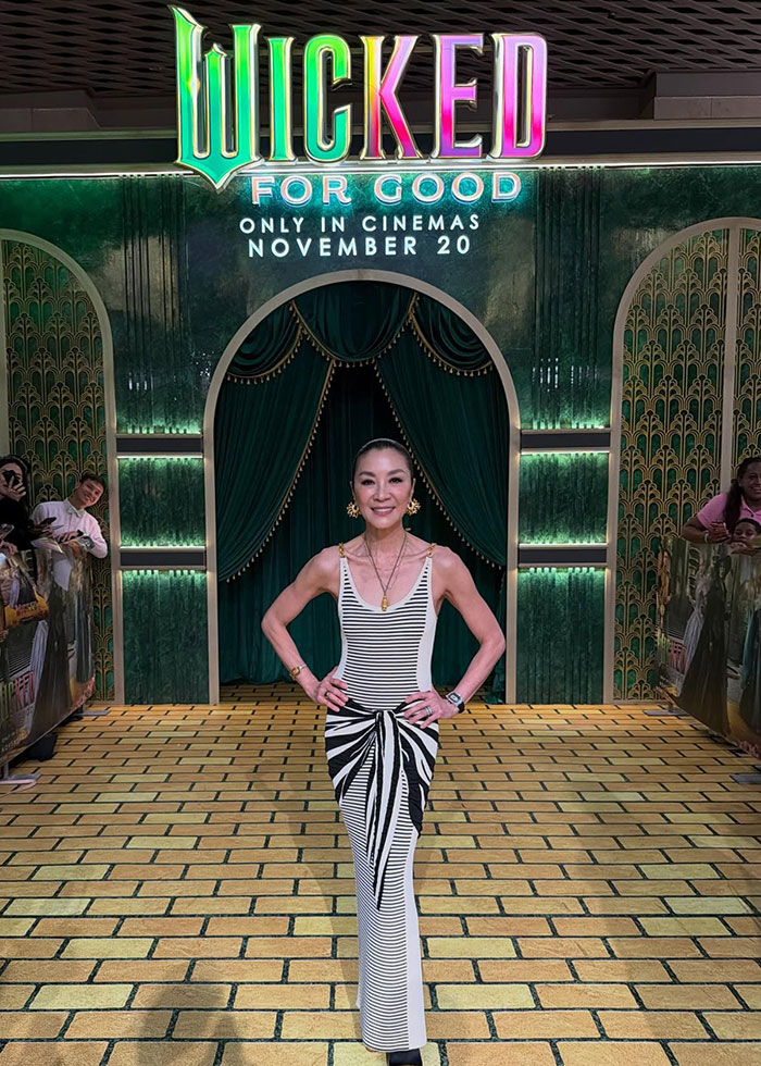 Michelle Yeoh posing at premiere in a striking outfit resembling a wasp nest, sparking an online meltdown.