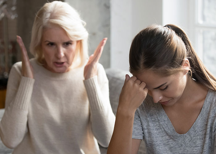 Woman frustrated during conversation while mil expects Thanksgiving dinner after 12-hour shift at home near window. Woman frustrated during conversation while mil expects Thanksgiving dinner after 12-hour shift at home near window.
