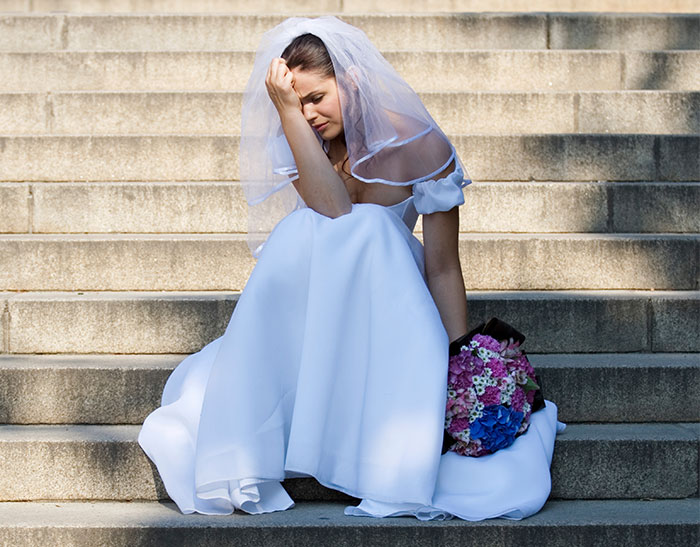 Bride sitting on steps looking upset, reflecting the impact of mom’s behavior ruining the wedding day. Bride sitting on steps looking upset, reflecting the impact of mom’s behavior ruining the wedding day.