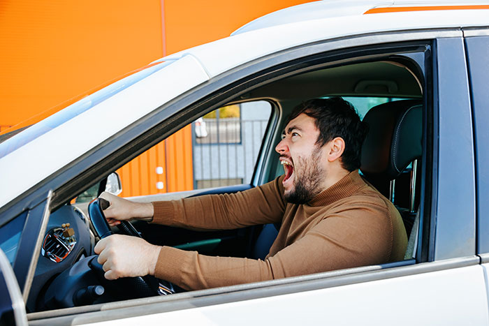 Man in a car yelling aggressively, illustrating tension related to MIL and family cutting contact with gay couple.