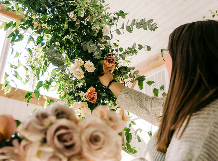 Bride arranging flowers for wedding decor, highlighting secret wedding invites and protecting family image.