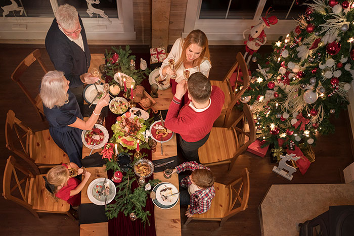 Family celebrating Christmas dinner indoors with festive decorations, capturing a mildly disturbing fact about holiday gatherings.