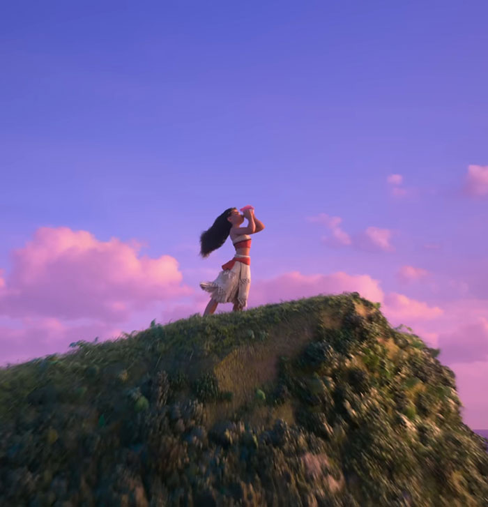 Animated Moana standing on a grassy hill, blowing a conch shell at sunset, related to Disney live-action controversy.