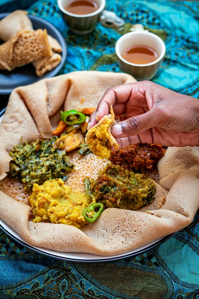 Traditional Ethiopian dish with injera and various stews, highlighting positive stereotypes about food from various countries.