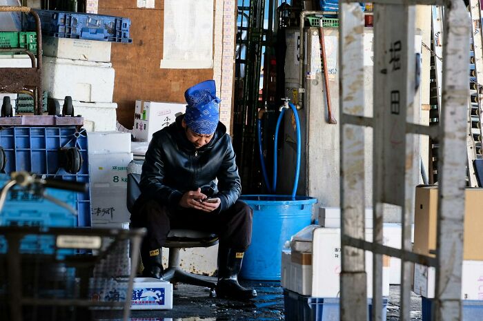 Worker in warehouse taking a break while sitting among crates, showcasing inventive ways workers got away with breaking rules