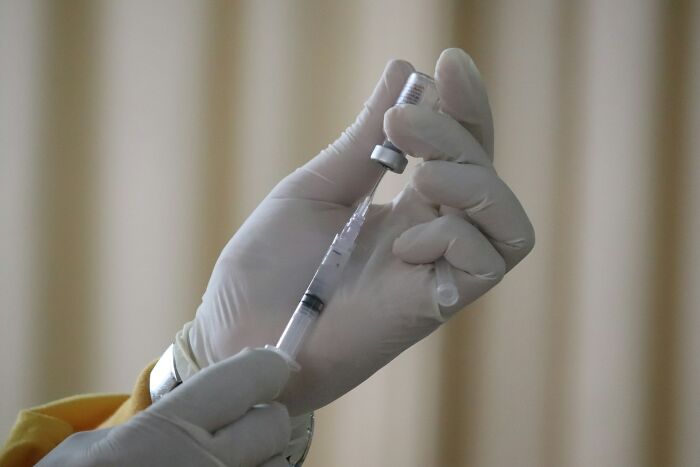 Close-up of gloved hands preparing a syringe, illustrating a real life example of the butterfly effect concept.