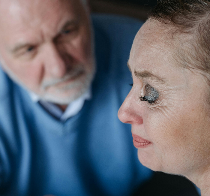 Older estranged parents looking concerned while woman cries, depicting family conflict after years of neglect and blocked contact.