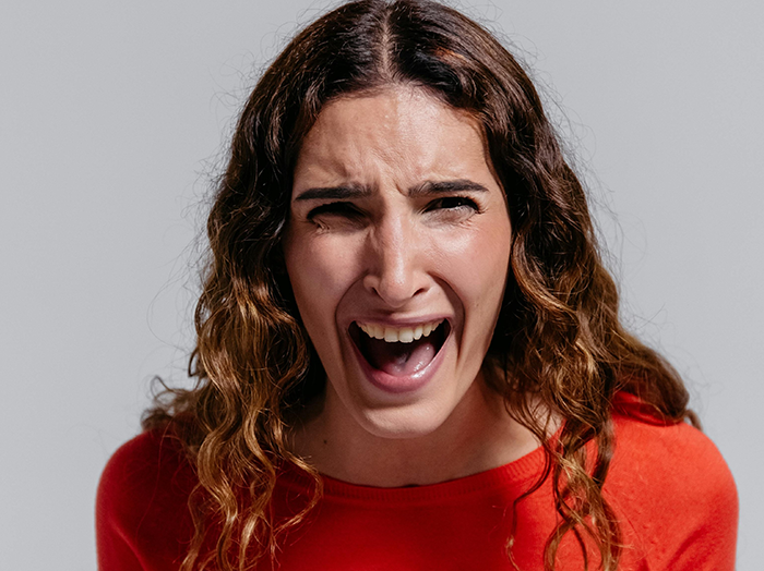 Woman with curly hair in red shirt showing distressed facial expression representing estranged parents and neglect issues