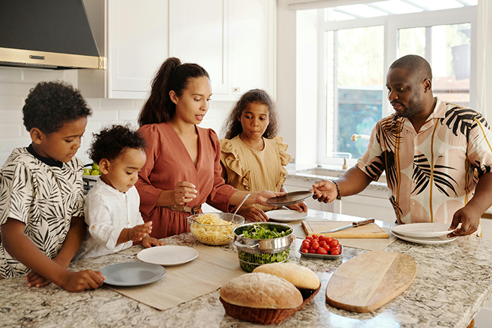 Family preparing meal together in kitchen, highlighting estranged parents and grandkids after years of neglect conflict.