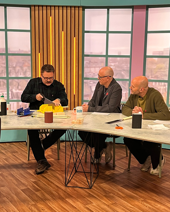 Nick Offerman making an x-rated comment during live broadcast while talk show hosts react at a studio table.