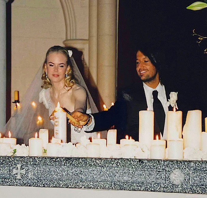 Bride and groom lighting multiple candles at a wedding altar, relating to Tom Cruise and Nicole Kidman split karma.