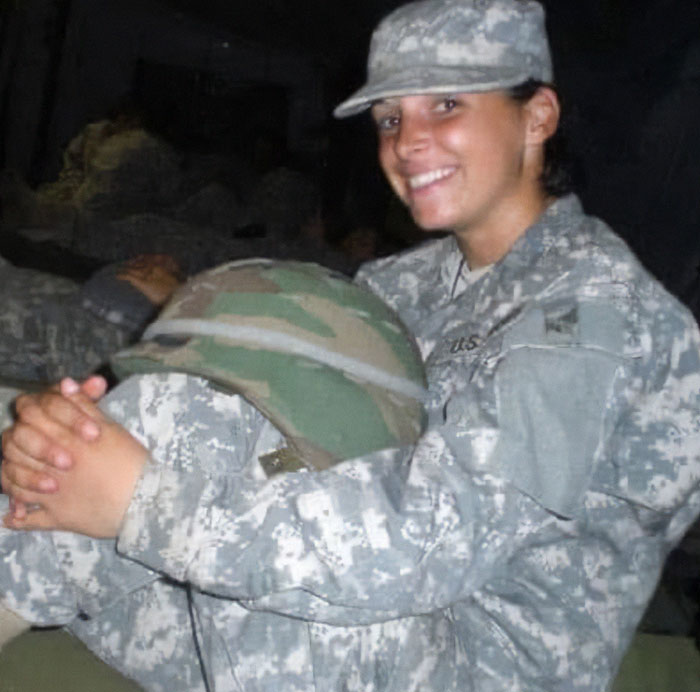 Woman in military uniform holding helmet, smiling indoors during a social experiment with US megachurches. Woman in military uniform holding helmet, smiling indoors during a social experiment with US megachurches.