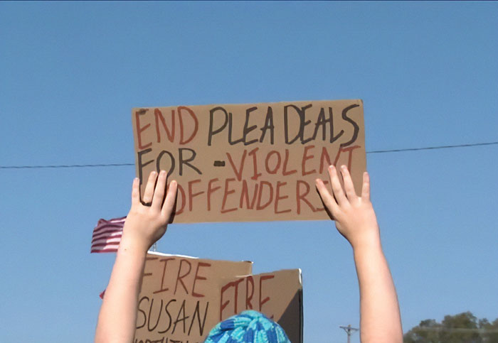 Protests erupt in Oklahoma with demonstrators holding signs against plea deals for violent offenders.
