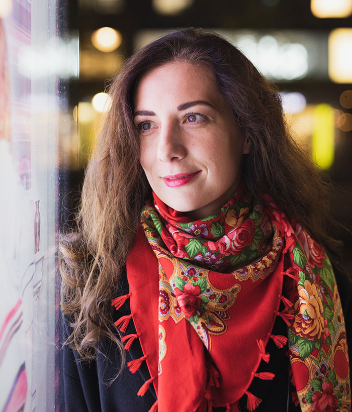 Young woman with long hair and colorful floral scarf, symbolizing people who walked away and started a new life.
