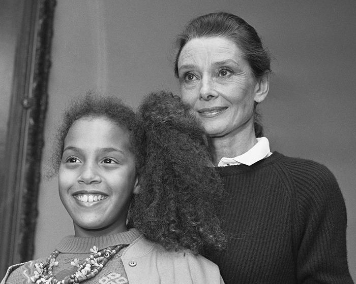 Audrey Hepburn with a young girl, showing natural aging and warm expressions in a candid black and white photo.