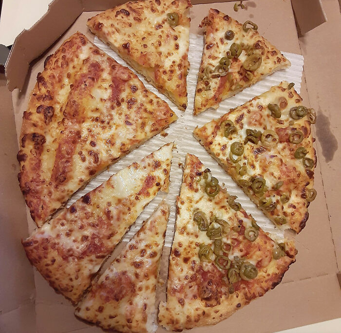 Slices of cheese and jalapeño pizza in a box, illustrating a lucrative loophole exploited in food portioning.