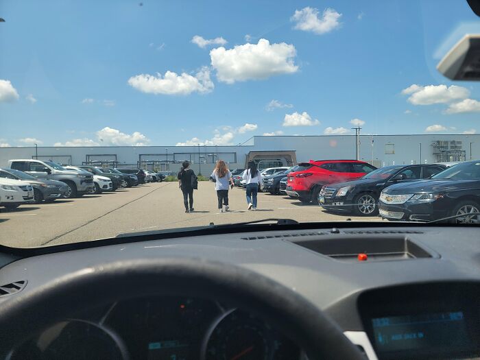 View from inside a car parked in a lot with people walking ahead, illustrating a lucrative loophole in everyday situations.