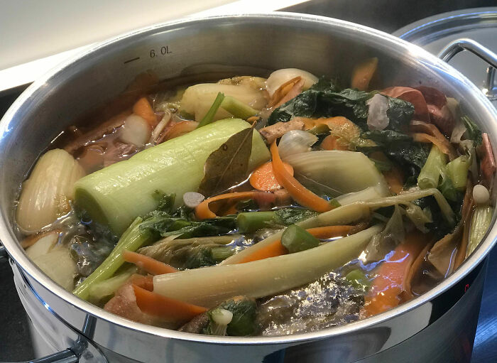 Large pot of simmering vegetables and herbs, illustrating kitchen tips to instantly upgrade cooking skills.