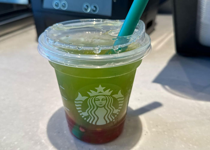Starbucks iced layered drink with green and red colors in a clear cup, representing discontinued foods people are upset about.