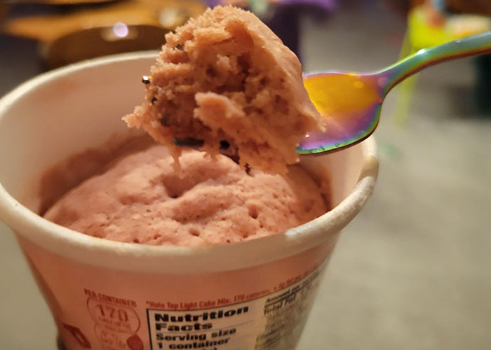 Close-up of a discontinued food item cup with a spoon holding a scoop of soft cake, highlighting foods people miss.