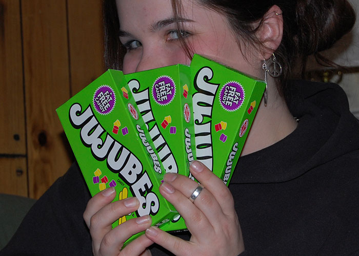 Person holding three bright green Jujubes candy boxes, a popular discontinued food that many people miss.