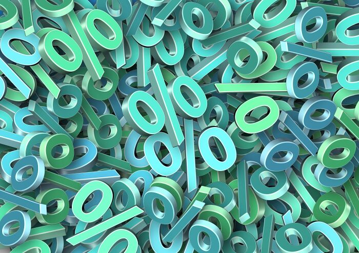 Close-up of numerous 3D percentage symbols in blue and green hues, representing challenges to belong in the 1% club.