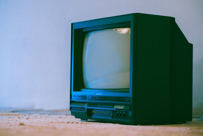 Old CRT television sitting on a dusty floor, evoking childhood habits and nostalgic moments from the past.