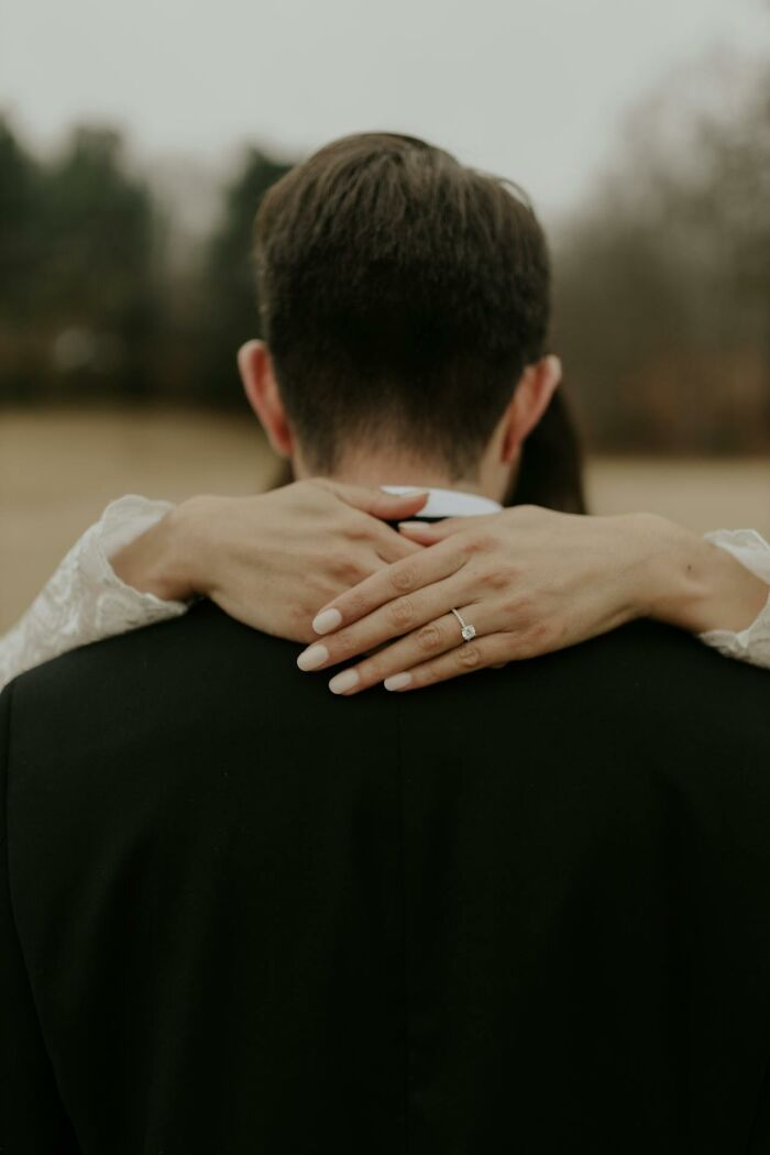 Couple embracing outdoors, showcasing a close connection and a visible engagement ring symbolizing marriage truth.