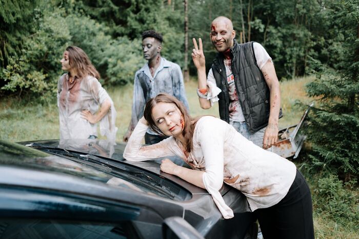 Group of people in zombie costumes acting bizarre in a forest, creating moments that make others question sanity.