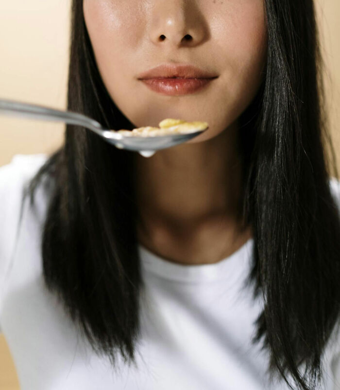 Close-up of a woman eating breakfast, focusing on lips and spoon, representing nurses of psych wards stories.