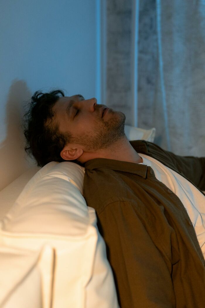 Man sitting on couch with eyes closed appearing tired, reflecting harsh truths about marriage reality.