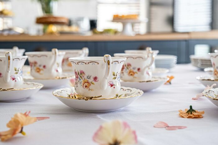Elegant floral tea cups arranged on a white tablecloth, symbolizing stories of compulsory things in life made optional.