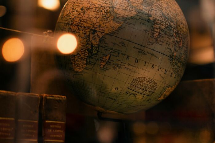 Vintage globe showing country outlines with warm lighting, highlighting geography and country flags quiz concept.