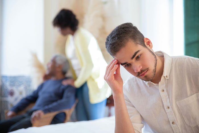 Young man looking worried and hiding while making a desperate call about newlywed issues on a radio show.