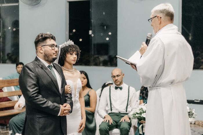 Couple standing before an officiant during a wedding ceremony, capturing a bizarre moment that made people wonder about sanity.