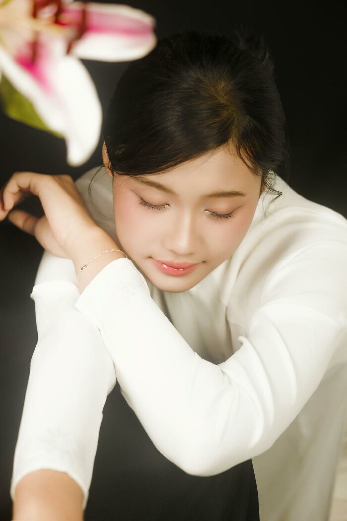 Young woman in white outfit with eyes closed, reflecting calmly, illustrating people who came back to life experiences.