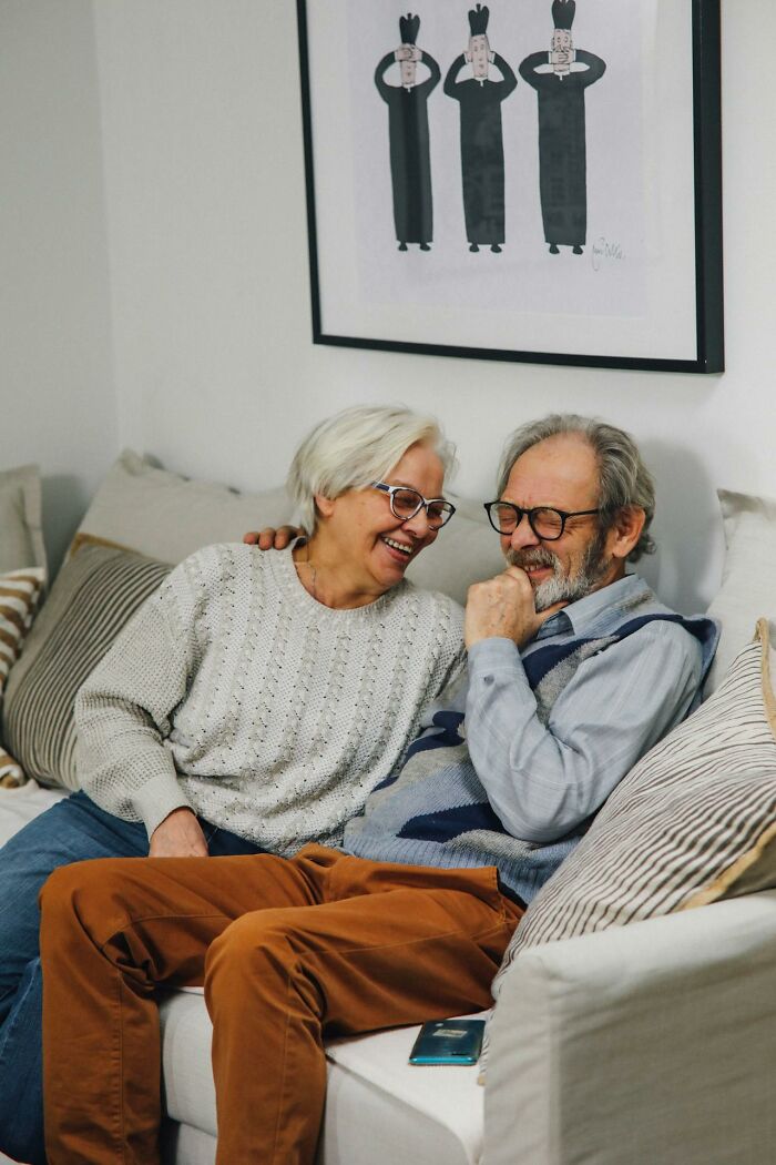 Elderly couple sharing a joyful moment on the couch, illustrating the realities and truths about marriage after years together.