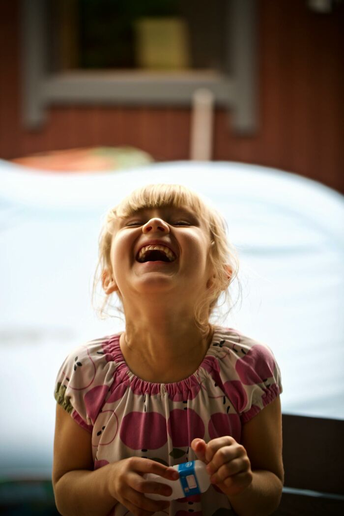 Happy young child laughing joyfully, capturing funny and serious moments parents realize they are raising monsters.