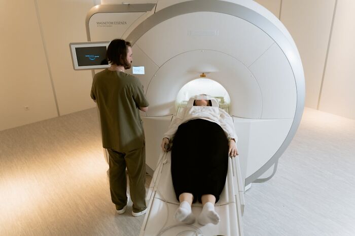 Patient undergoing MRI scan with technician nearby, illustrating mysterious medical issues and diagnoses in healthcare.
